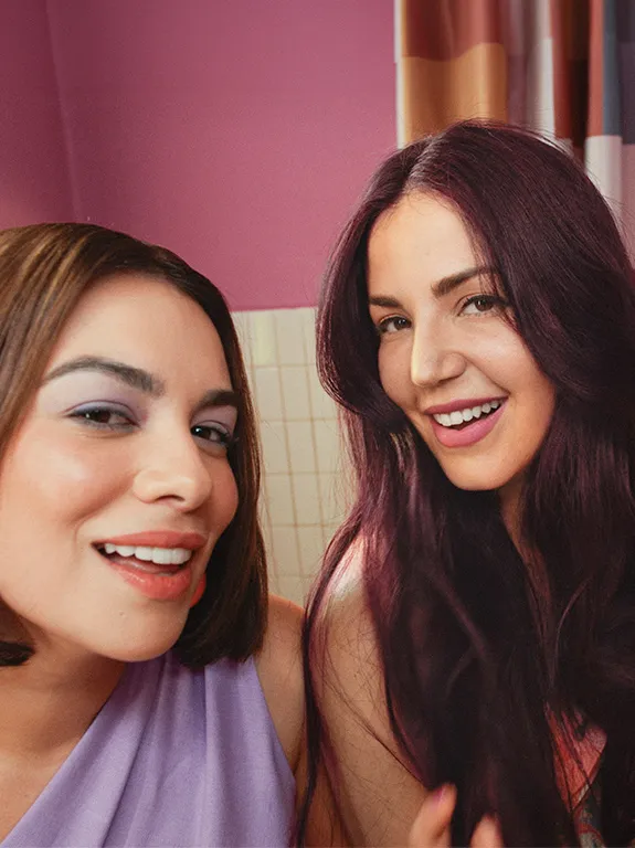 Three smiling women with different hairstyles and colors